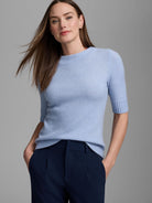 Light blue fuzzy mock neck sweater with short, ribbed sleeves.