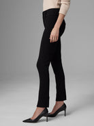 Black slim pants with a visible side zipper, angled front seams, and an ankle-length hem.