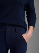 Dark navy knit scuba slim pants, featuring two silver front buttons and a side pocket.
