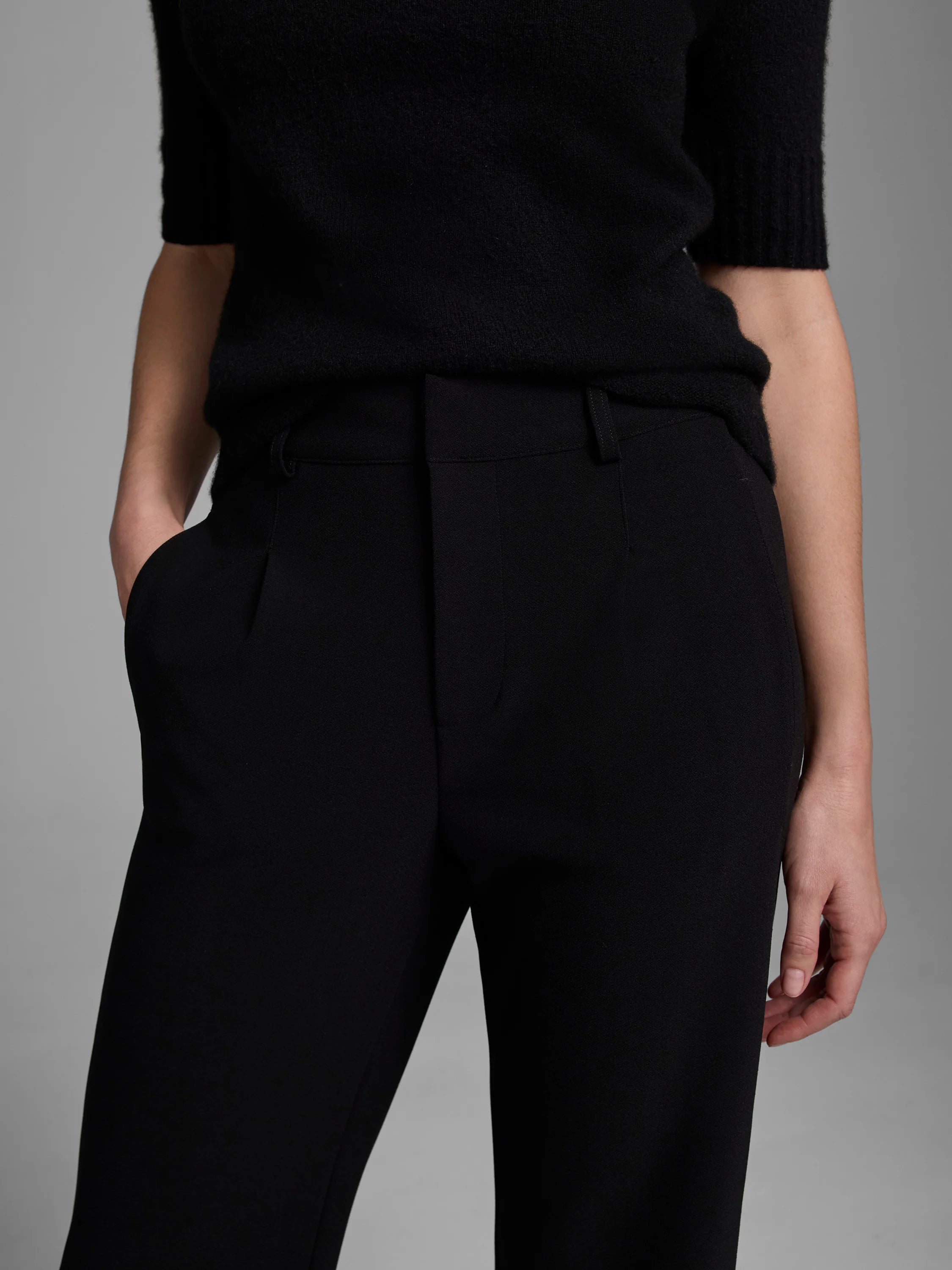 Black wide-leg trousers with pockets, shown on a model wearing a black top.