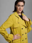 Yellow twill trench with black double-breasted buttons, wide lapels, shoulder flap, and gathered cuffs.