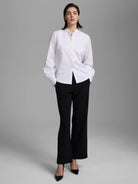 White shirt with a band collar, partial button placket, and long sleeves with gathered cuffs.