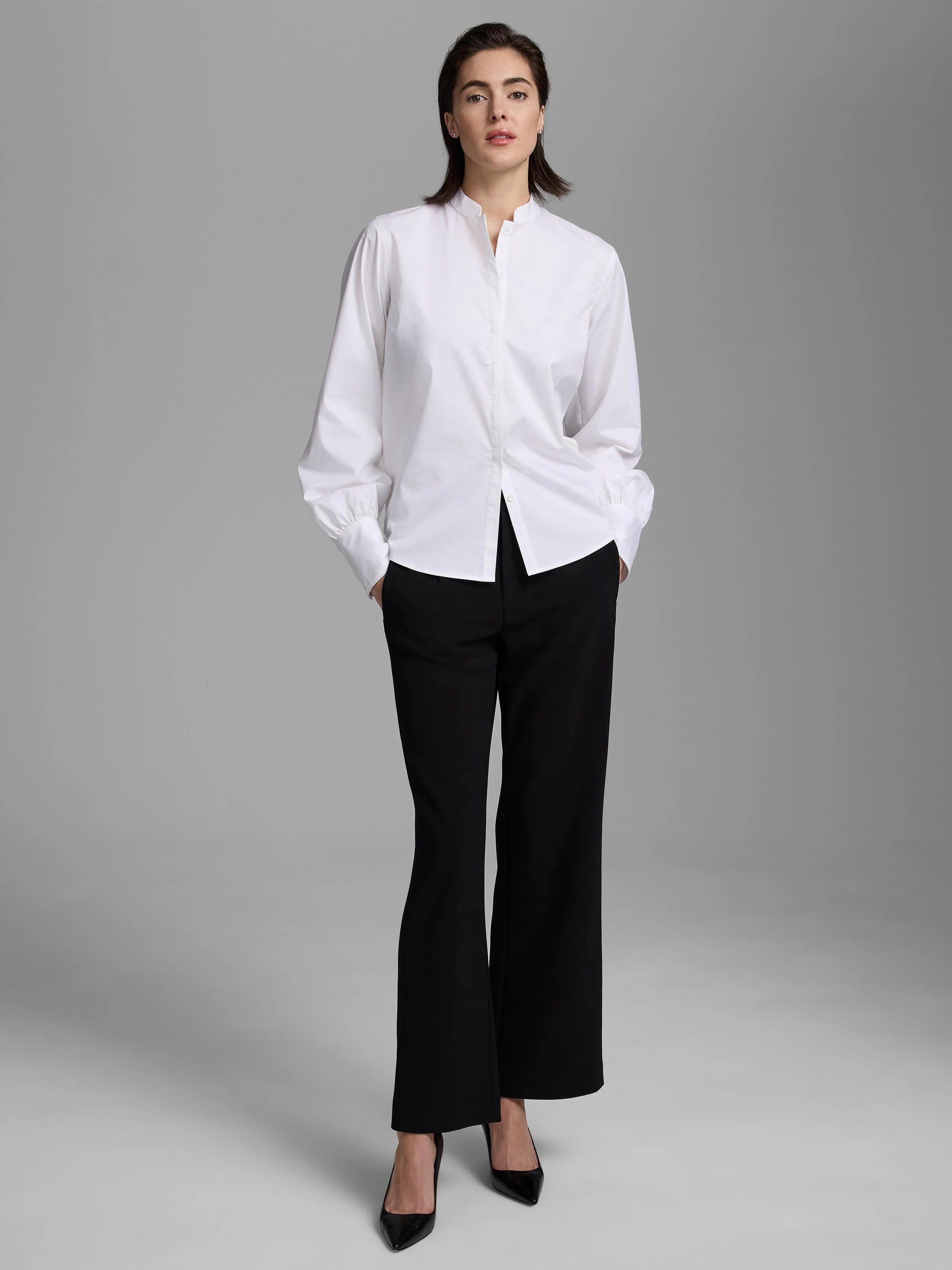 White shirt with a band collar, partial button placket, and long sleeves with gathered cuffs.