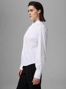 White long-sleeve shirt with band collar, concealed button-front, and wide buttoned cuffs, worn by a model.