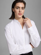 White shirt with band collar, partial button placket, and long sleeves with gathered three-button cuffs.