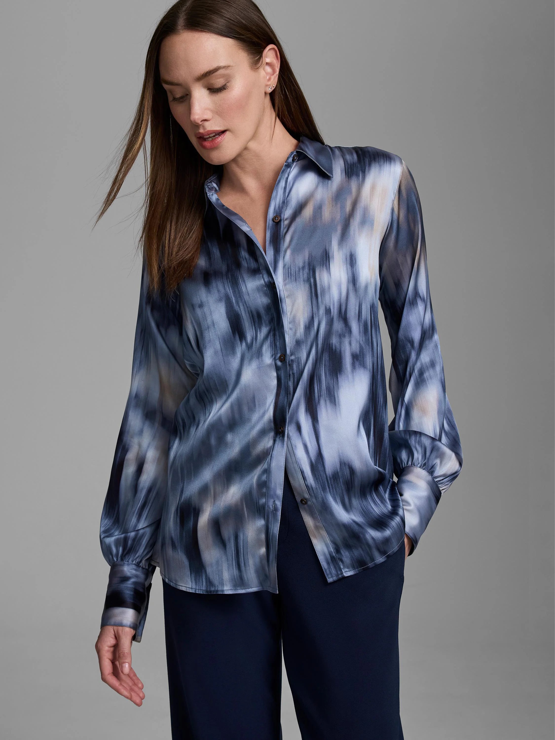 Silky button-front shirt in blue and grey abstract pattern, with long sleeves and gathered cuffs.