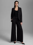 Black wide-leg pants with a high-rise fit and adjustable tie waist.
