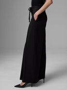 Black wide-leg apron pants with a high tie-waist.