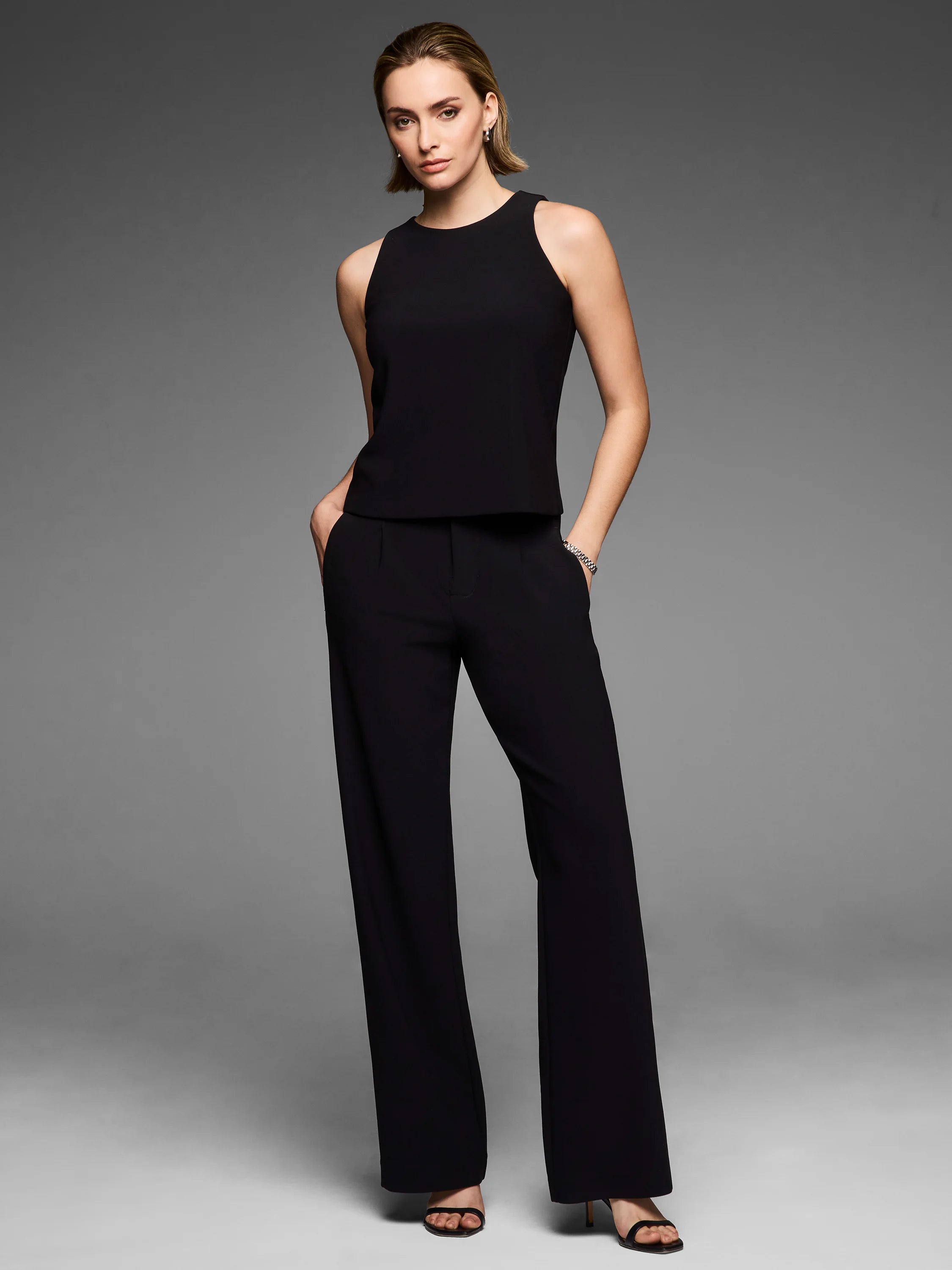 Black knit scuba tank with a high neck and sleeveless design.