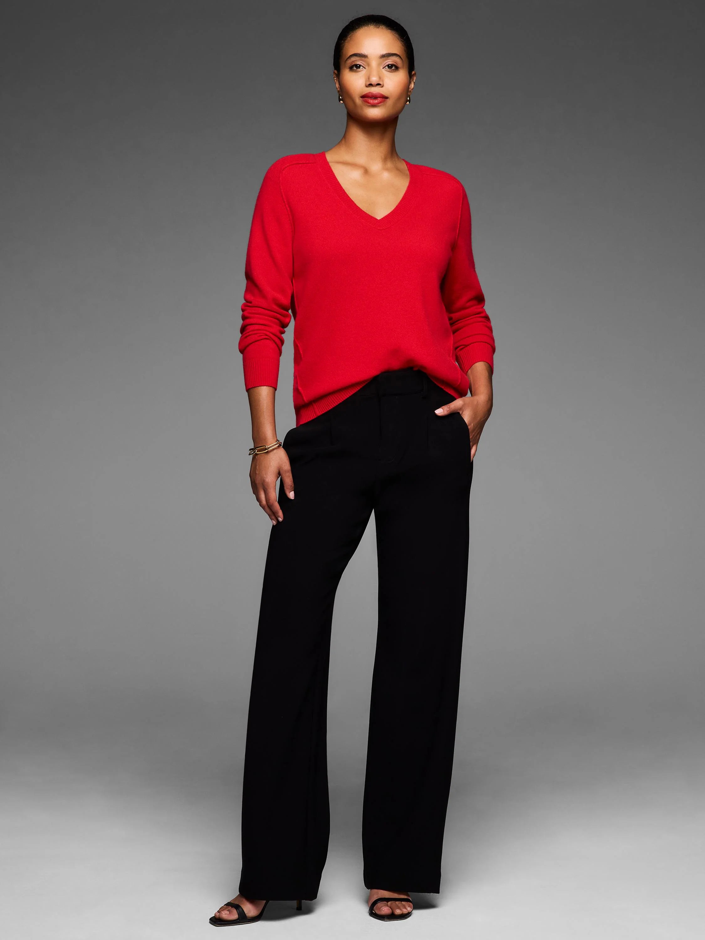 Red V-neck sweater with a smooth fine knit texture, featuring ribbed cuffs and hem.