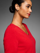 Red V-neck sweater with a finely knit texture, worn by a model.