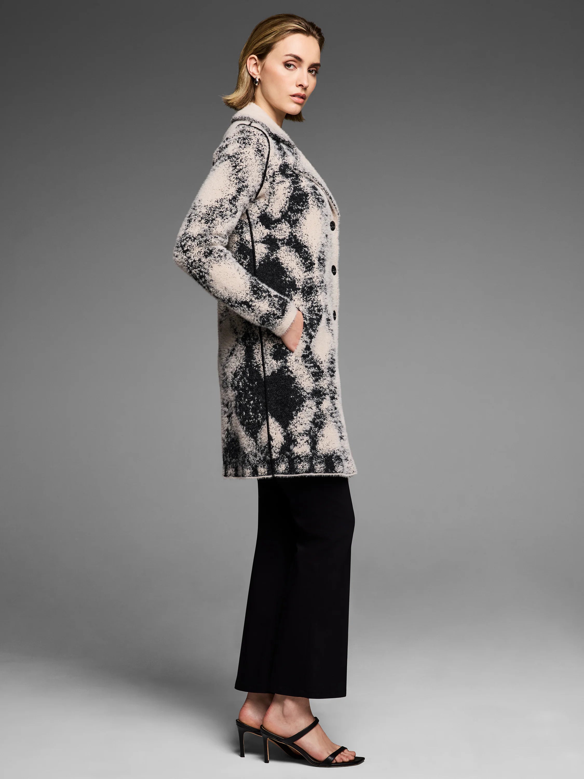 Textured black and off-white double knit coat with a mottled pattern, front buttons, and pockets.