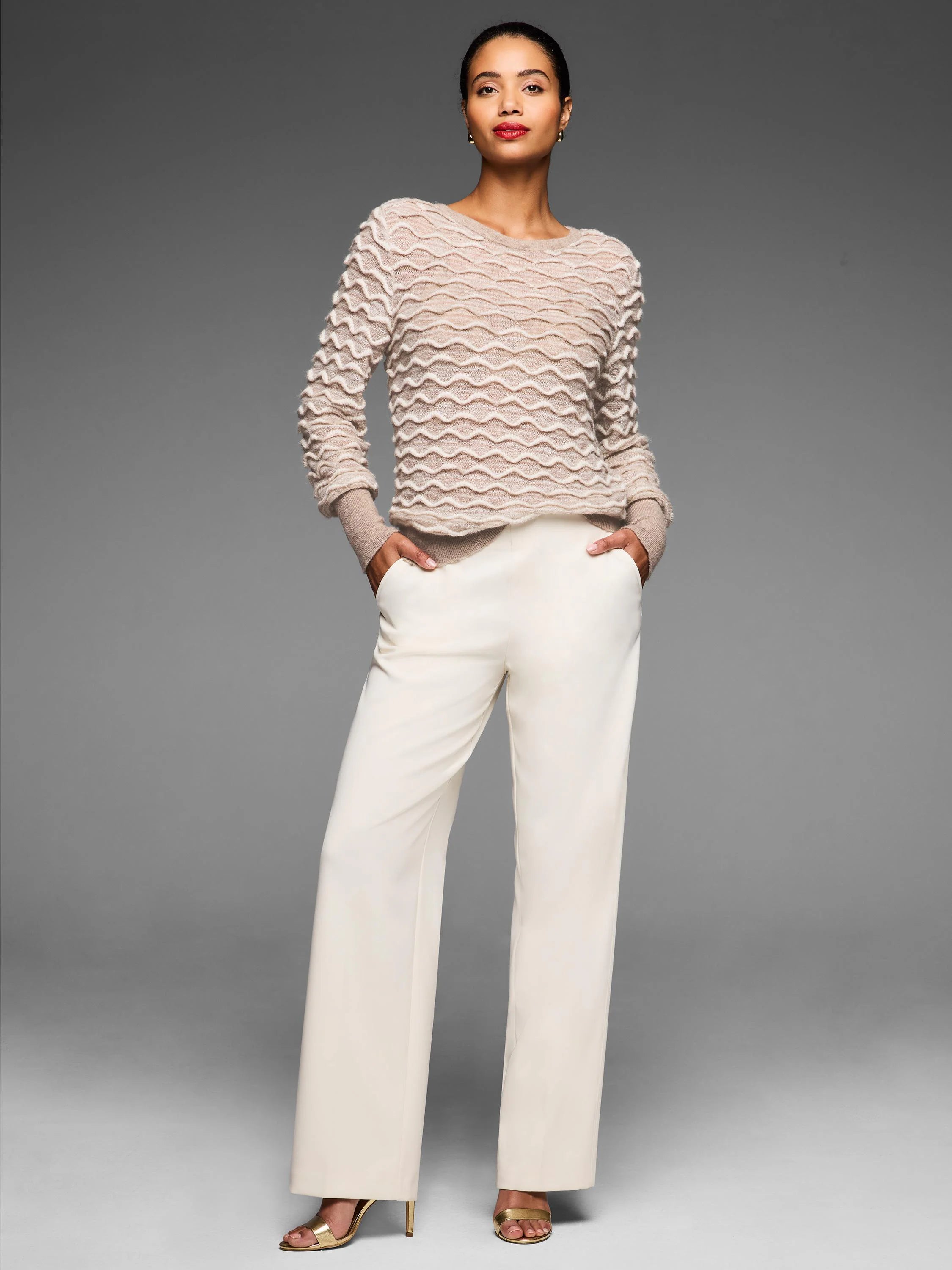 Beige sweater with a prominent, all-over raised cream-colored wave stitch pattern.