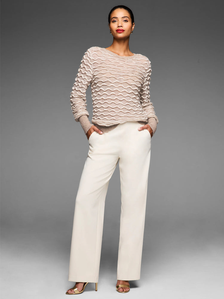 Light beige long-sleeve sweater with a raised, undulating cream wave stitch pattern.