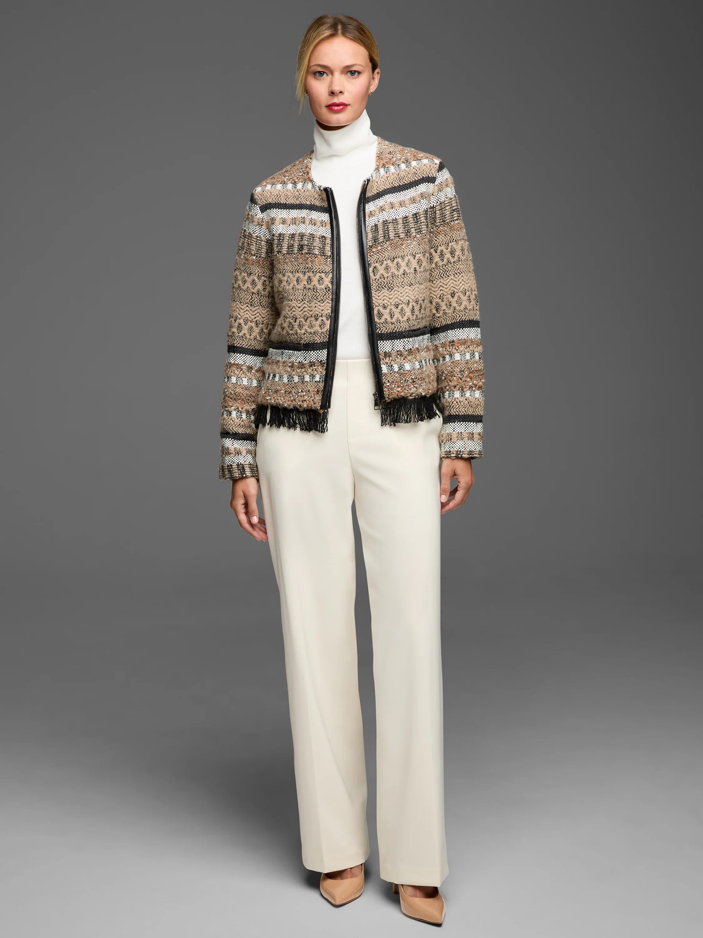 Collarless jacket: beige, black, white knit weaving patterns, black trim, and fringed hem.
