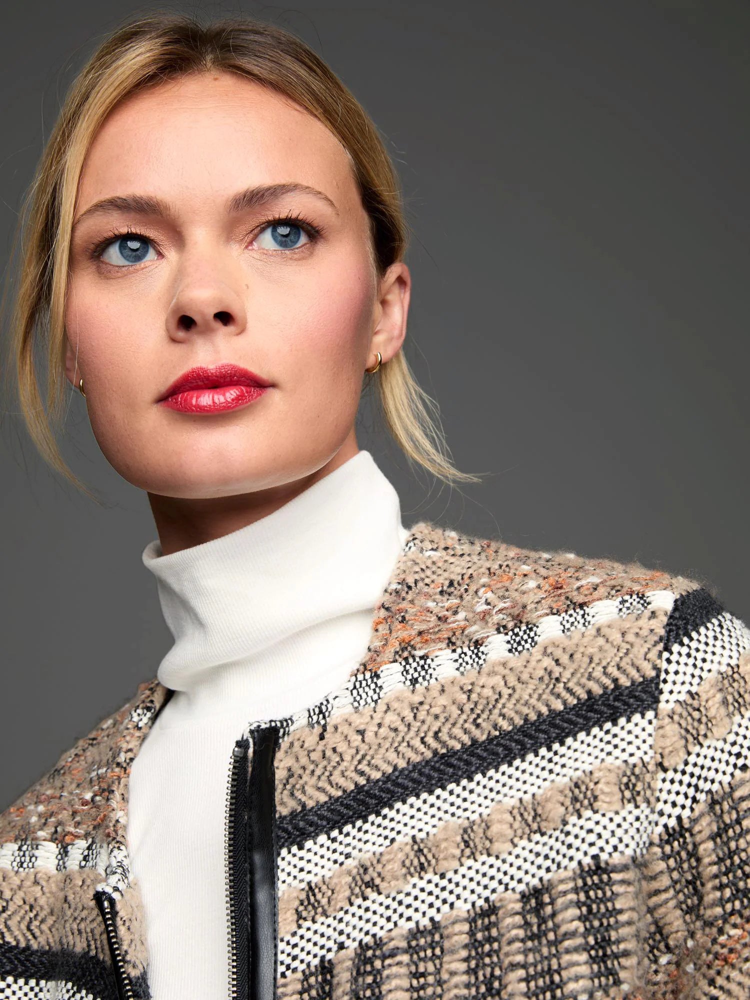 Knit woven jacket in tan, black, white, with textured stripes & black trim along the silver zipper.