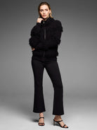 Black jacket featuring dense placed fringe texture and a silver front zipper.