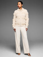 Cream, full-zip jacket with horizontal rows of fringe and a textured knit fabric.