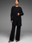 Black long open knit coat with lapel collar, ribbed sleeves, and two front patch pockets.