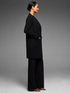 Black long open-front coat with ribbed sleeves and two front patch pockets.