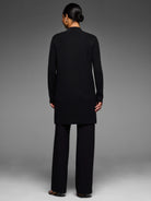 Black Juliette Coat, mid-thigh length, mock neck, and long sleeves. Worn from behind.