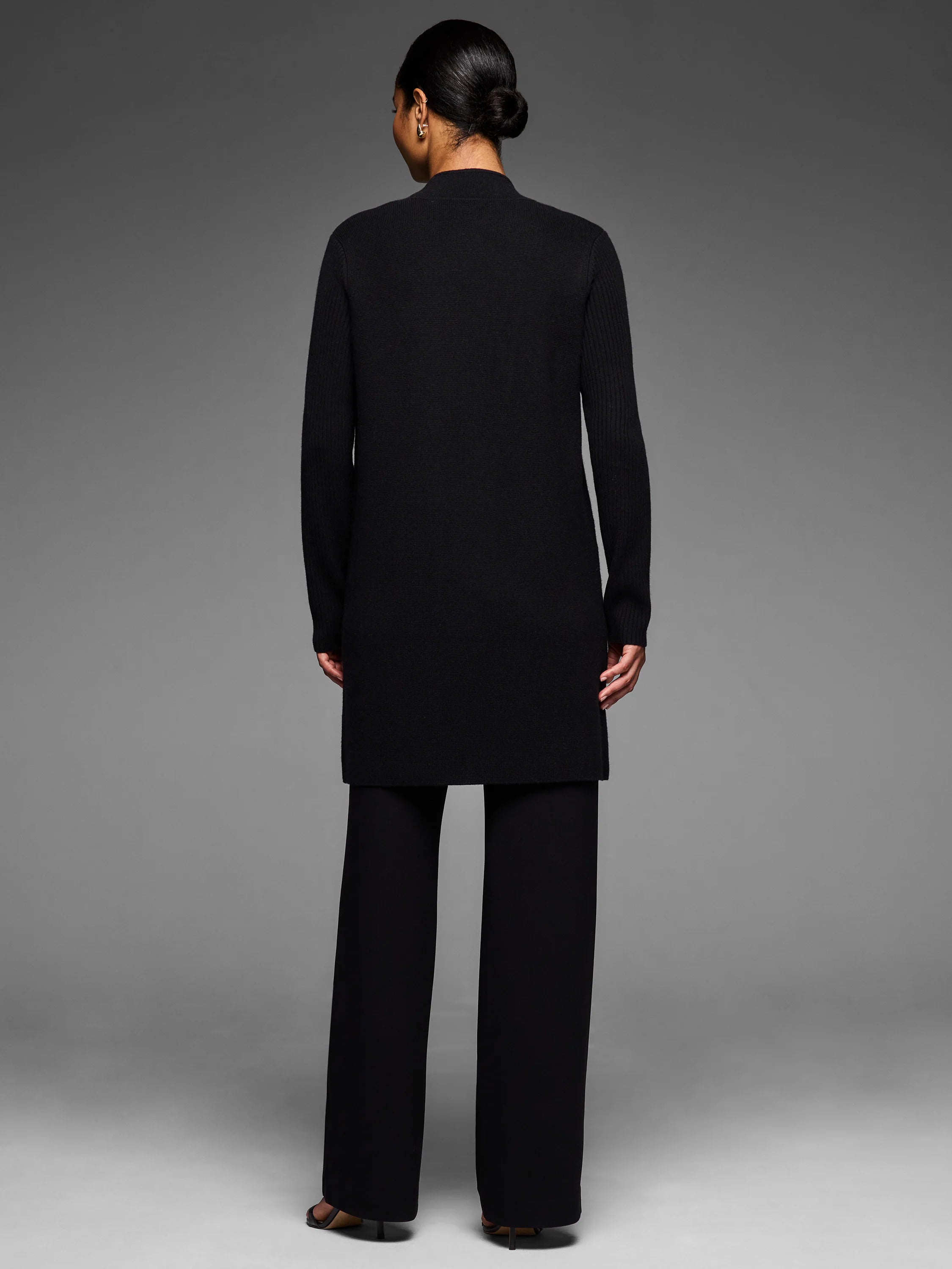 Black Juliette Coat, mid-thigh length, mock neck, and long sleeves. Worn from behind.