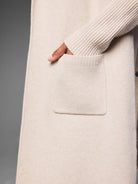 Light beige cashmere blend coat with a patch pocket, ribbed opening, and ribbed sleeve cuff.