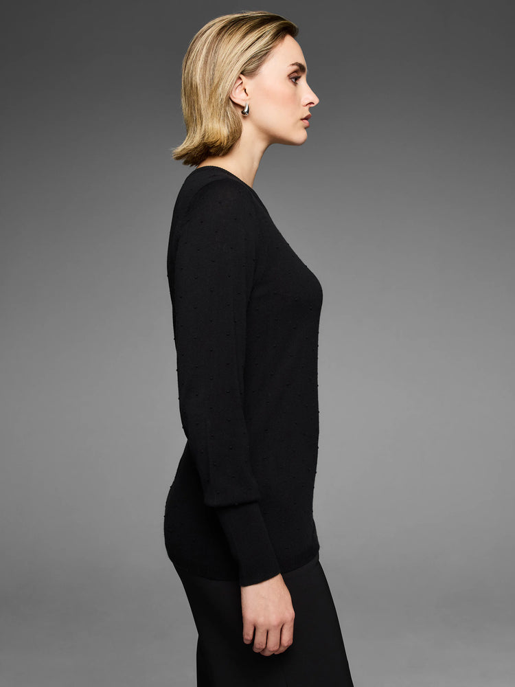 Black long-sleeve sweater featuring a subtle raised dot texture, shown on a model.