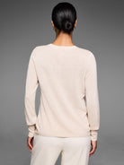 Light beige sweater with all-over raised dot texture, shown from the back on a model.
