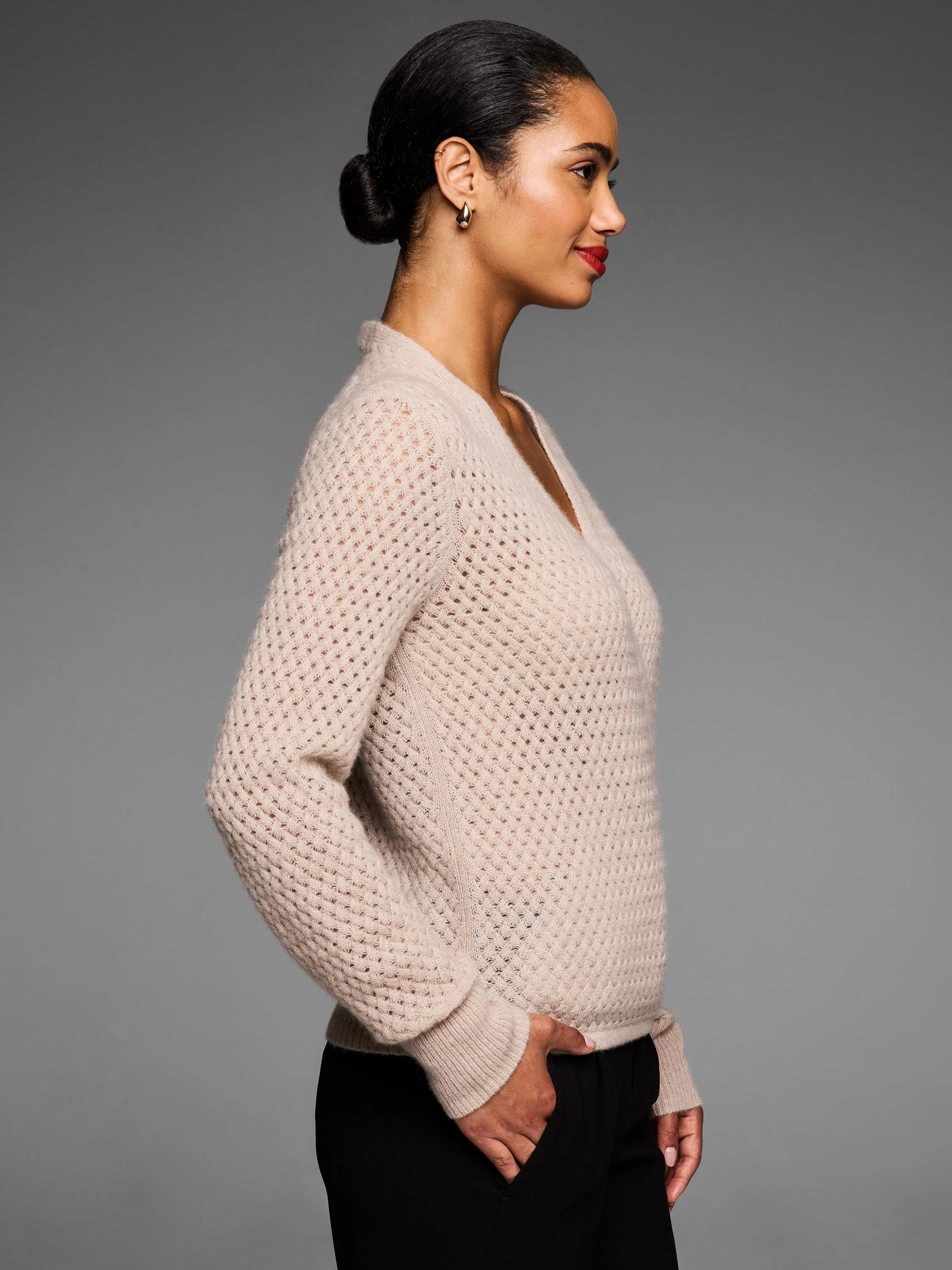 Beige cashmere pointelle V-neck cardigan with soft, openwork knit texture.