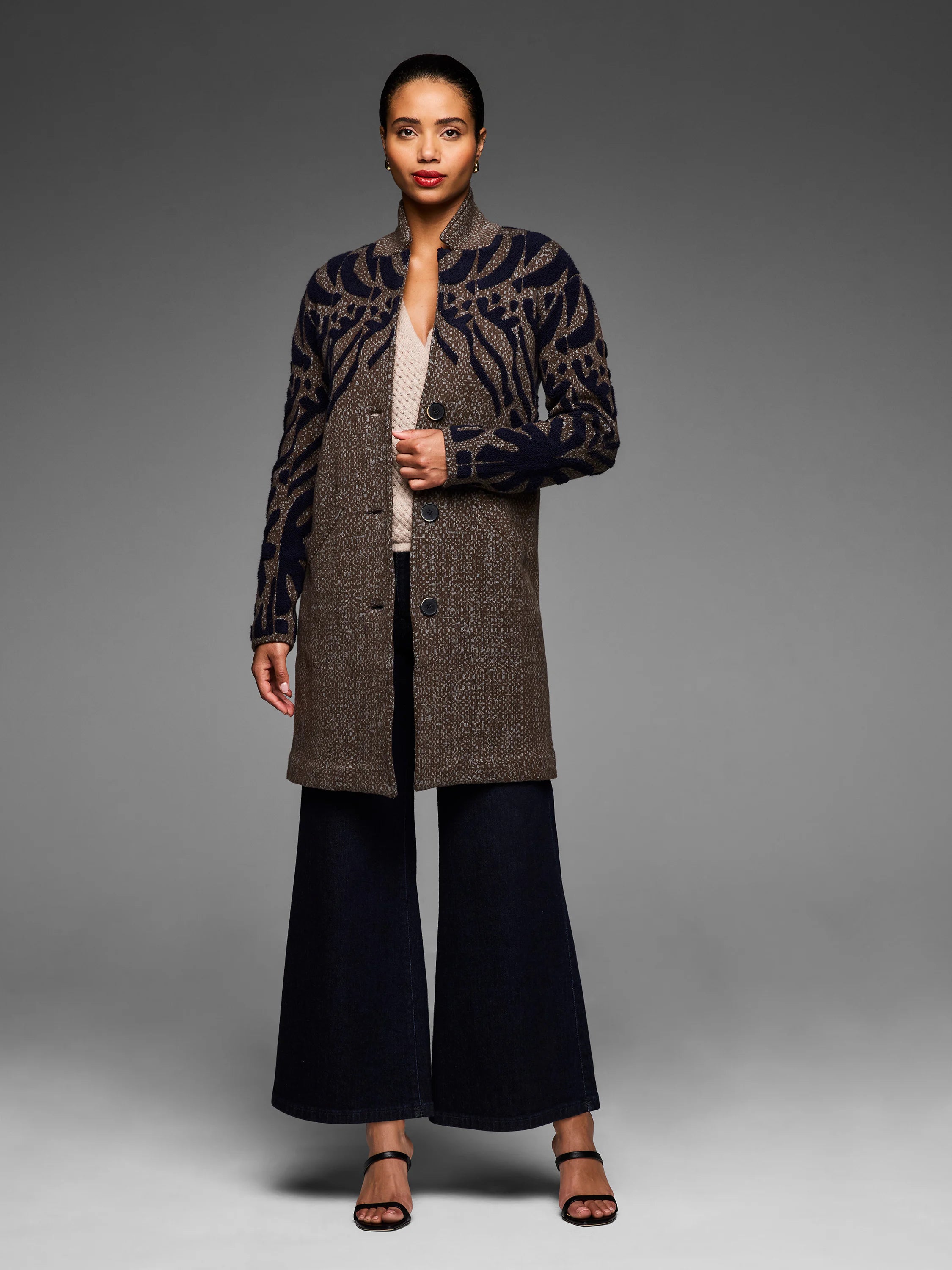 Brown tufted double-knit coat. Dark blue abstract pattern on upper body/sleeves. Stand collar, button front, mid-thigh.