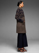 Navy & brown tufted double knit coat. Abstract, zebra-like pattern on top; solid brown lower. Mid-thigh length.