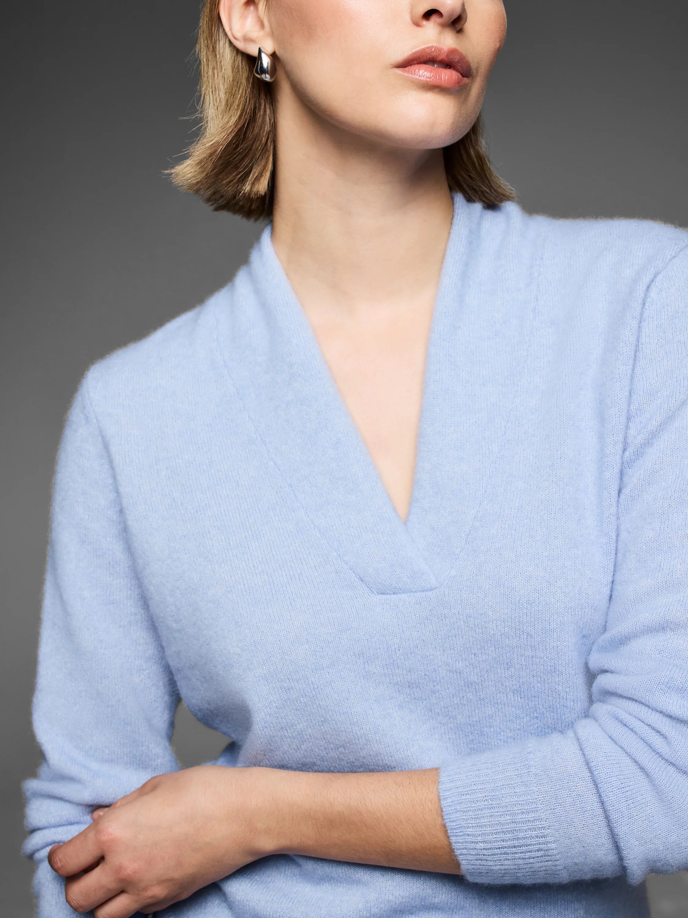 Light blue long-sleeved cashmere sweater with a V-neck and soft, fuzzy texture.