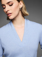 Light blue cashmere sweater with a built-up V-neck and soft, fuzzy texture.