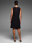 Black sleeveless knit scuba dress. Features full back zipper, draped side detail, and angled hem.