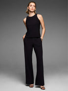Black knit scuba wide-leg trousers with side pockets, worn by a standing model.