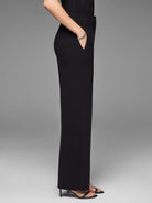 Black knit scuba wide-leg trousers, shown full-length on a model from the side, reaching the floor.