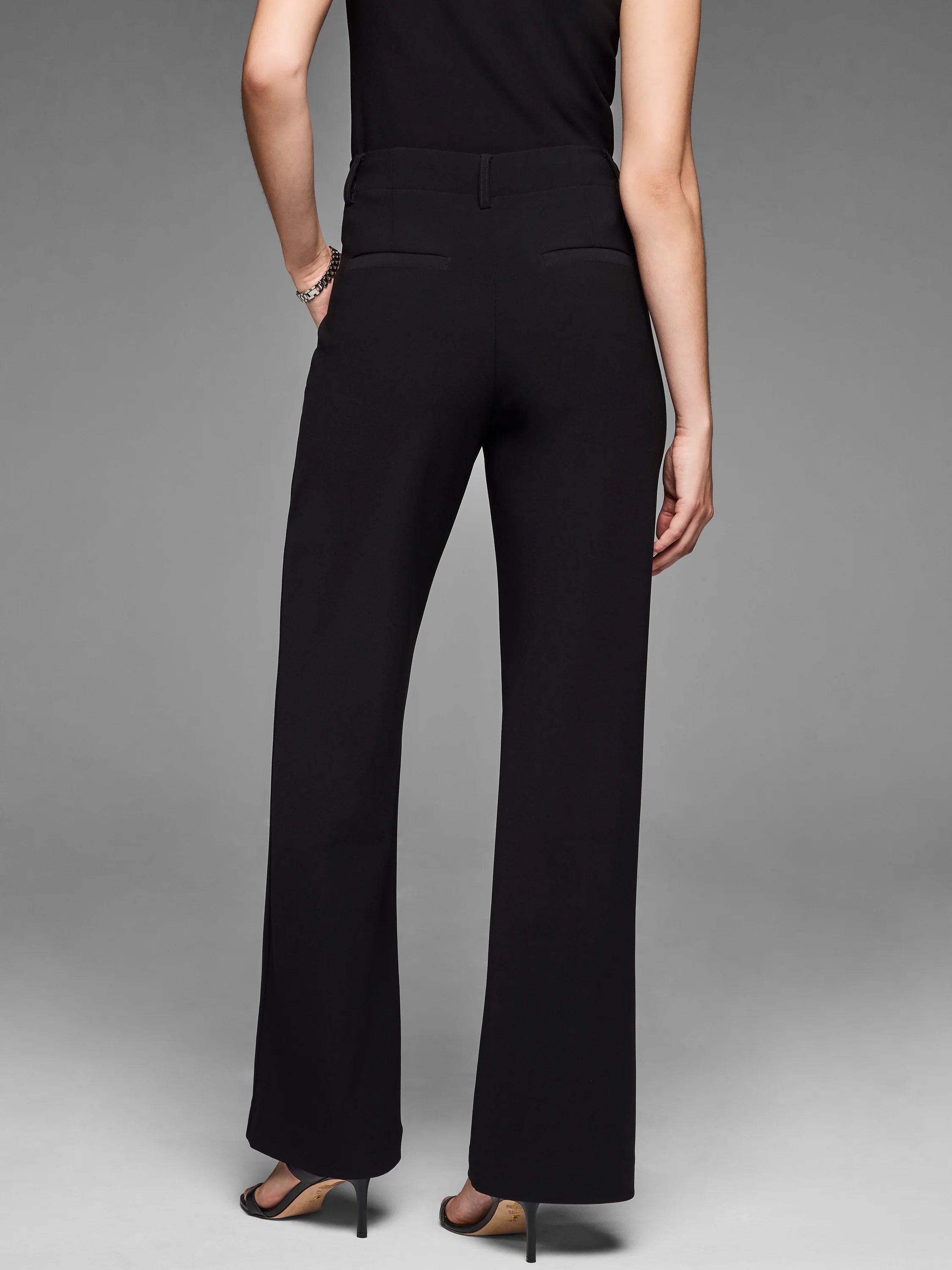 Black wide-leg trousers. Features include smooth knit fabric, high waist, belt loops, and back welt pockets.