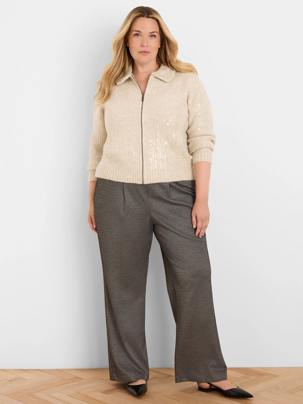Beige knit jacket with collar, full zipper, and visible silver sequins throughout the fabric.