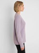Lavender V-neck sweater with a fuzzy texture, long sleeves, and subtle openwork detailing on the shoulders.