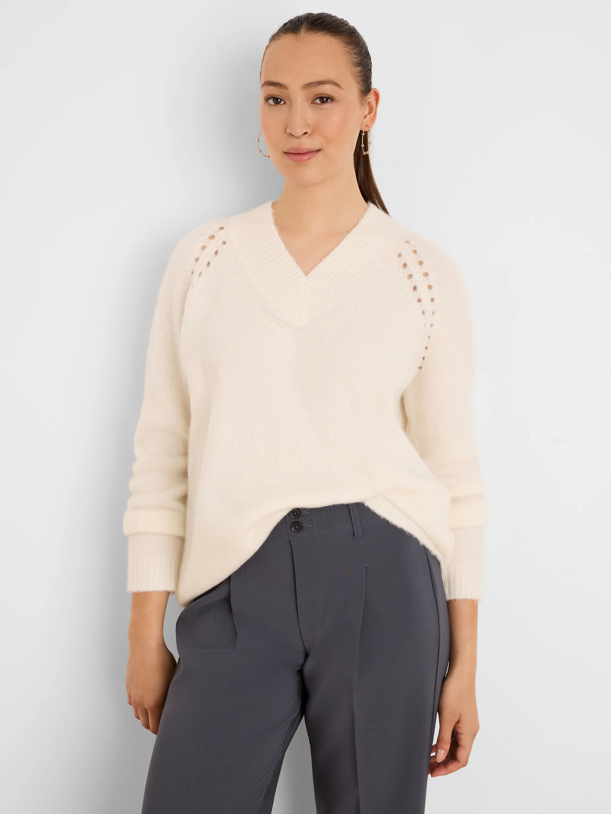 Cream, fuzzy V-neck sweater with raglan eyelet shoulder details and ribbed cuffs.