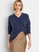Dark blue fuzzy V-neck sweater with openwork shoulder details and ribbed cuffs.