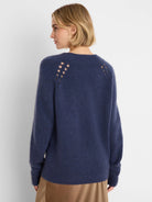 Deep blue fuzzy knit sweater with shoulder cutouts, seen from the back on a model.