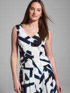 White sleeveless top with navy and black abstract brushstroke print. V-neck.