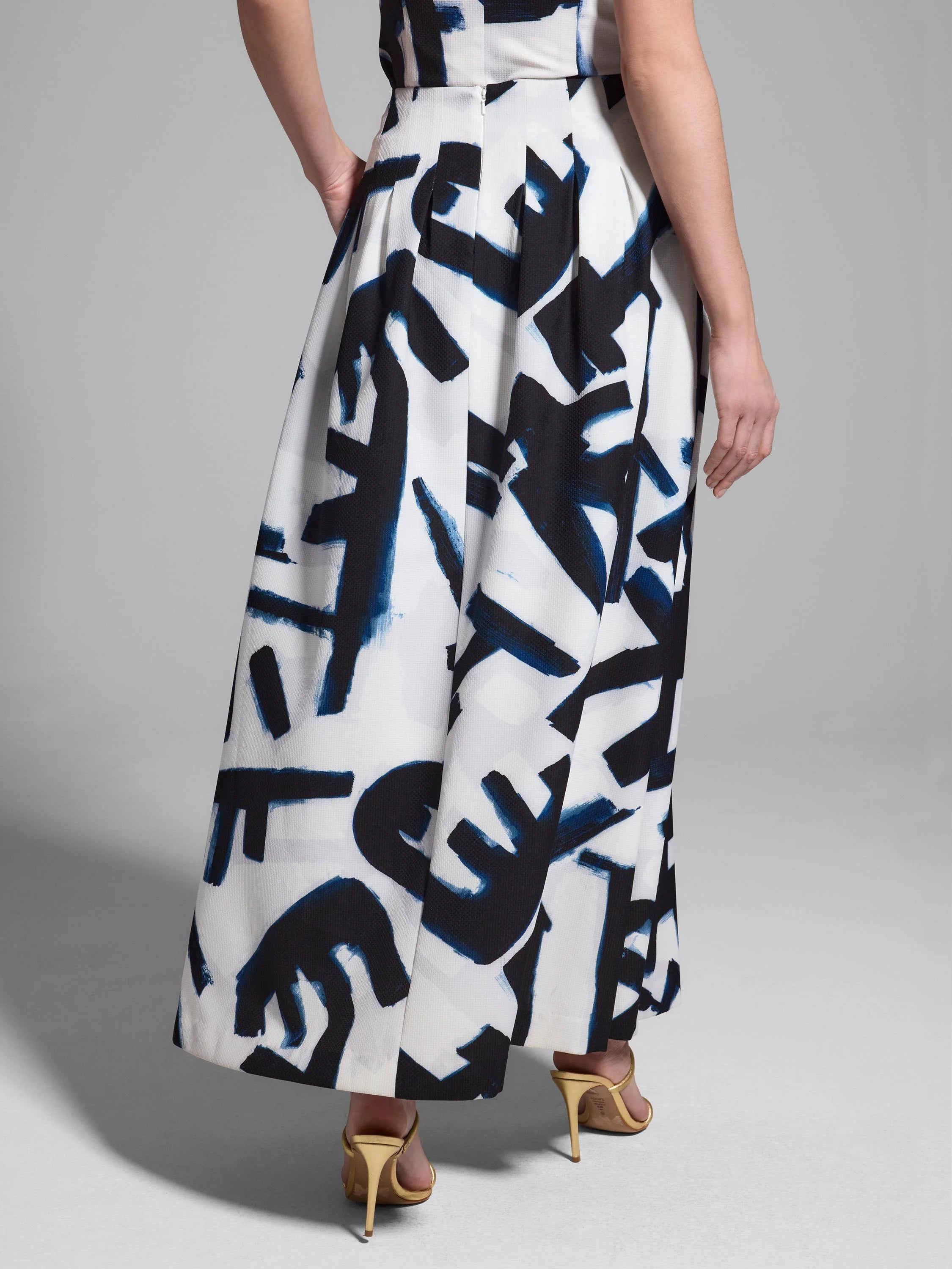 White pleated maxi skirt with a dark blue and black abstract print.