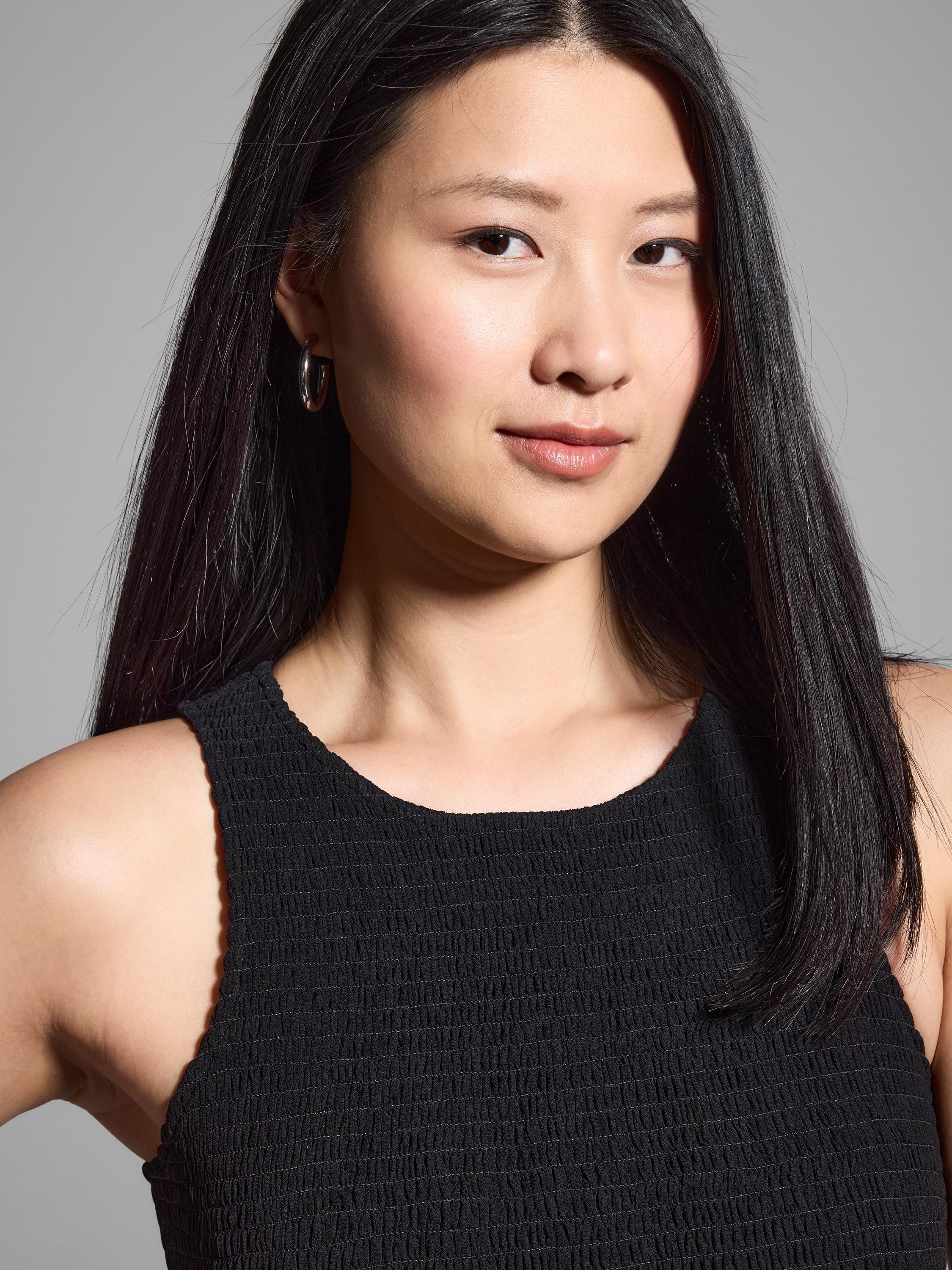 Black smocked chiffon sleeveless dress.  Close-up shows textured fabric.