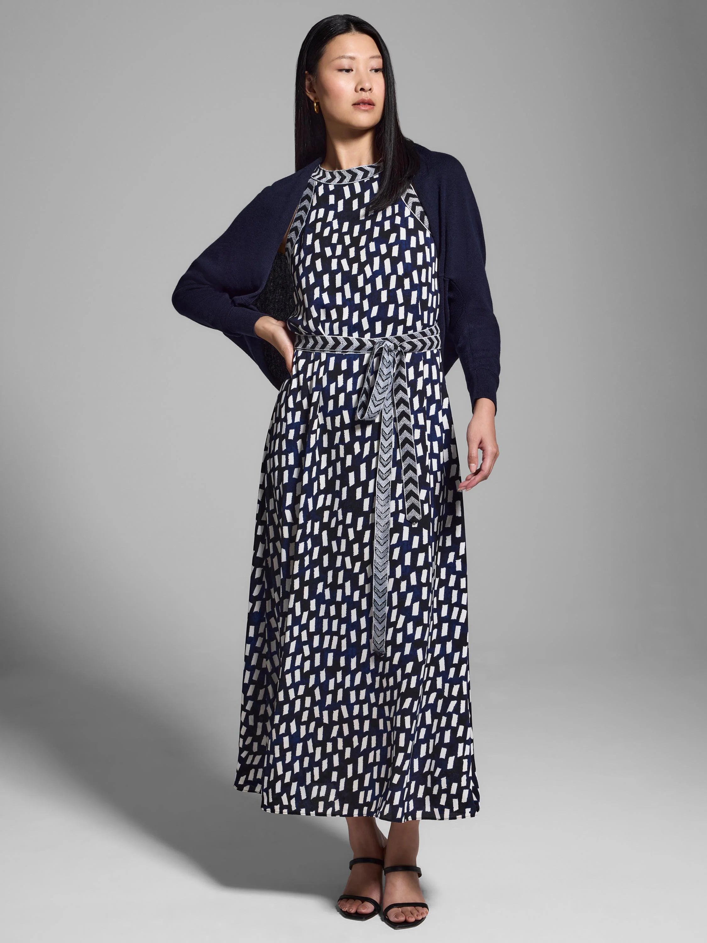 Midi dress with navy & white abstract print, belted waist, and a matching navy cardigan.