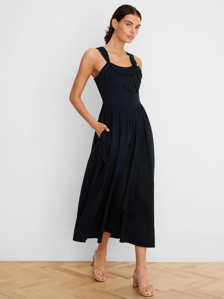 Navy midi dress with leaf appliques on bodice, sleeveless, v-waist, full skirt, and side pockets.