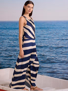 Sleeveless navy blue and cream striped dress. Diagonal stripes on top, horizontal on wide-leg bottom, cinched waist.