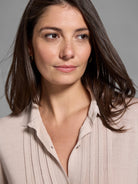 Beige ribbed knit sweater with a collared neckline and button placket.